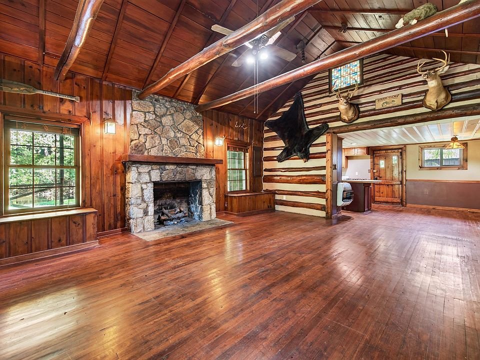 Living room with wood floors and a stone fireplace